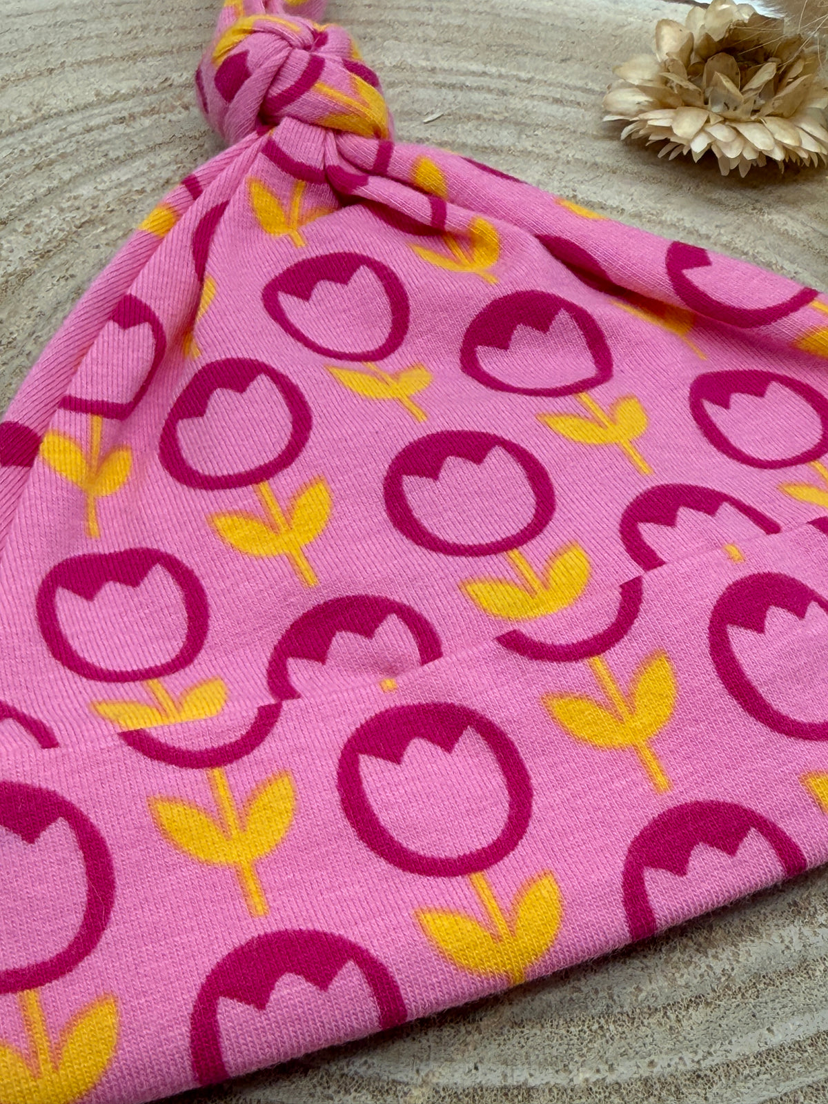Babymütze mit Knoten – rosa mit Blumen Motiv