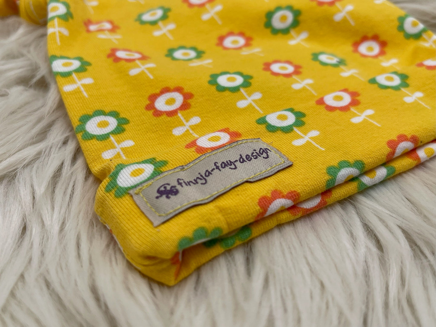 Babymütze mit Knoten – gelb mit Blumen Motiv