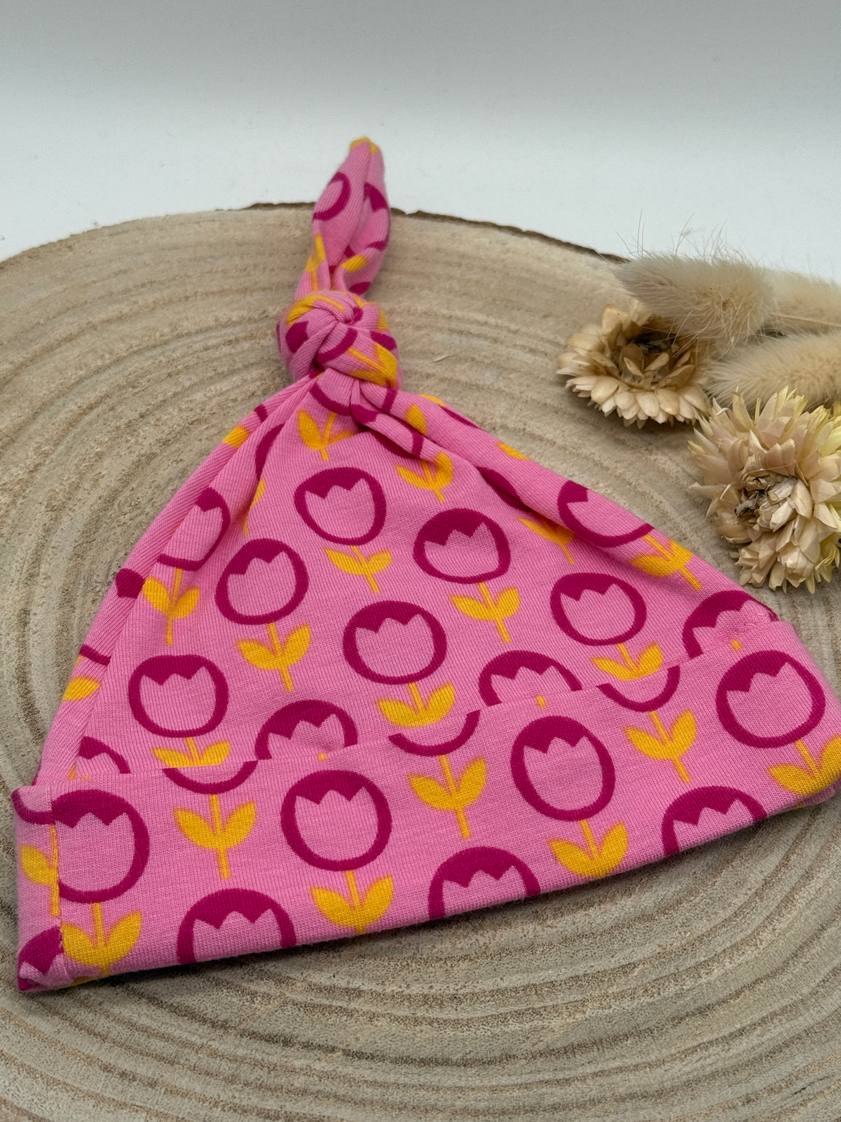 Babymütze mit Knoten – rosa mit Blumen Motiv